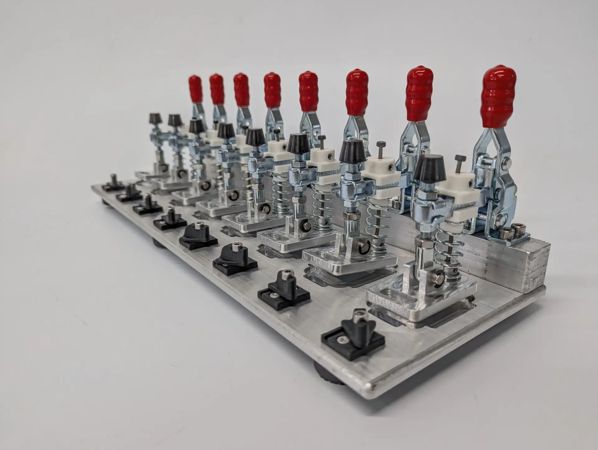 Custom automation fixture with rows of toggle clamps on a machined aluminium plate